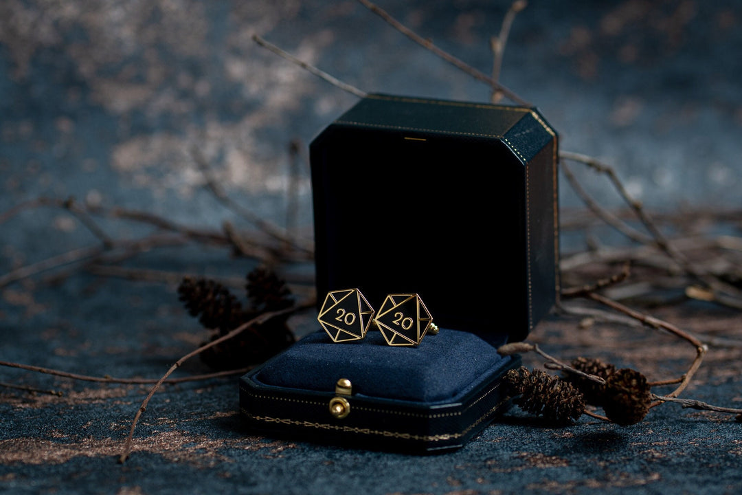 Gold D20 Cufflinks with black enamel sitting in a gift box.