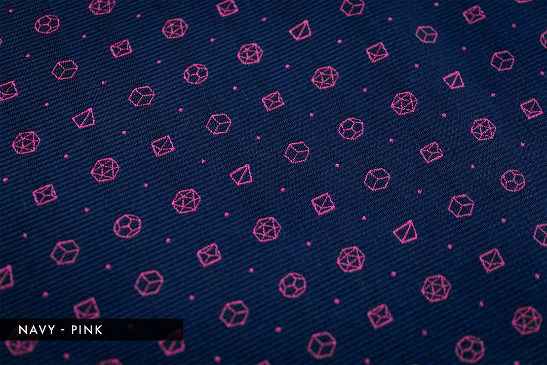 Detail of polyhedral dice pattern in navy with pink dice motifs. Fantasy-inspired necktie perfect for TTRPG fans who want unique accessories.