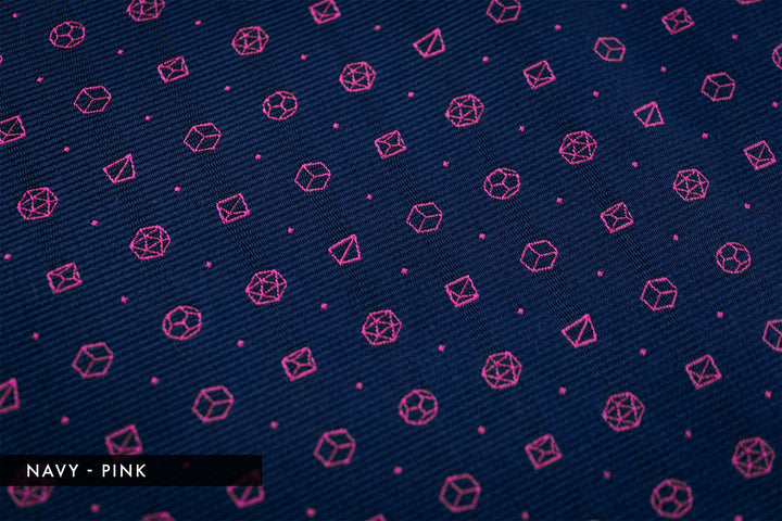 Detail of polyhedral dice pattern in navy with pink dice motifs. Fantasy-inspired necktie perfect for TTRPG fans who want unique accessories.