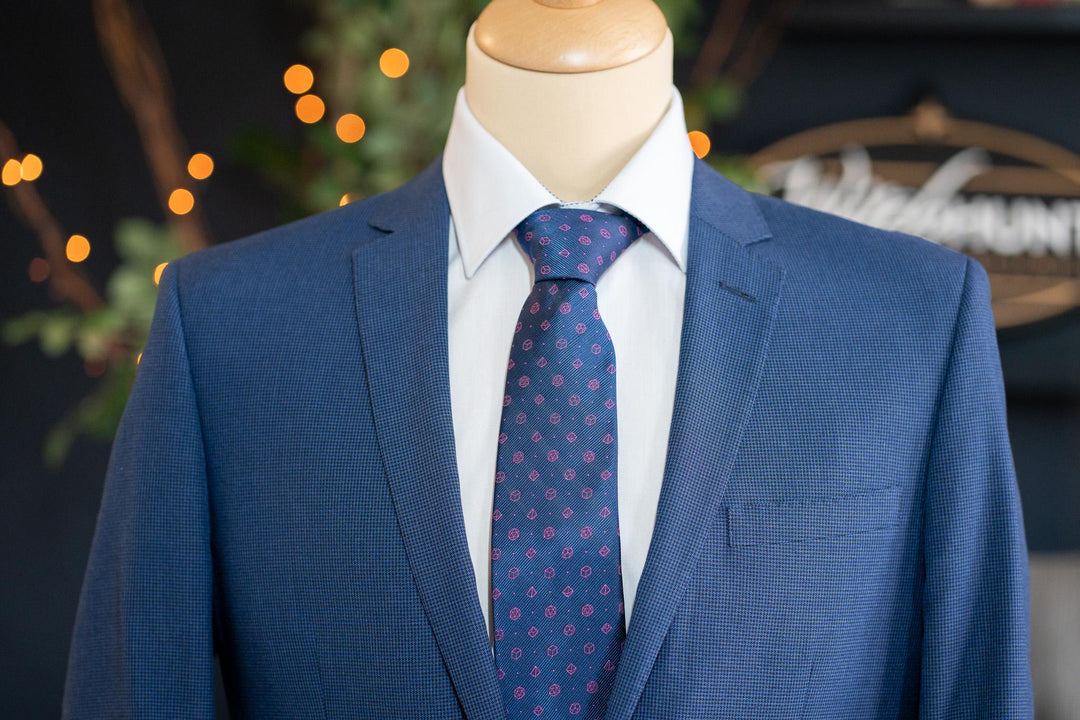 Polyhedral dice patterned tie in navy and pink. Ideal for tabletop RPG players looking to add a D&D-inspired touch to business or formal outfits.