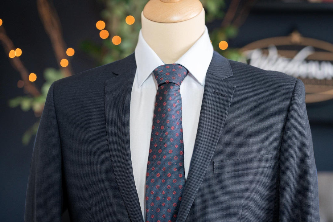 Elegant polyhedral dice design necktie in navy with red dice patterns. Perfect D&D-inspired necktie for TTRPG fans who want a subtle fantasy accessory for formal wear.